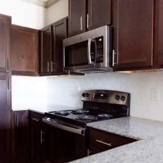 Modern kitchen with dark cabinets and stainless steel appliances.