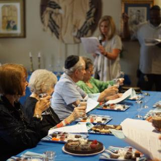 A joyful gathering around the dining table, sharing food and drinks.