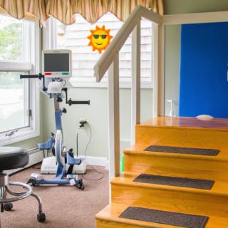 A rehabilitation area featuring an exercise bike and stairs for therapy exercises.