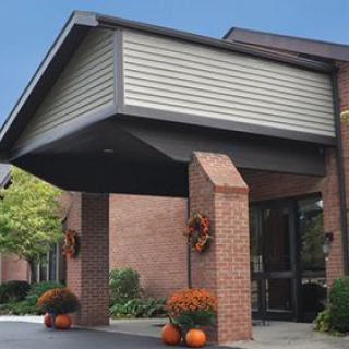 Entrance of a brick building with autumn decorations.