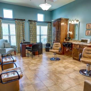 A cozy salon interior featuring seating, mirrors, and stylish decor.