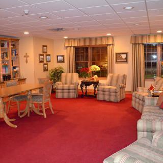 A cozy living room with red carpeting and comfortable seating arrangements.