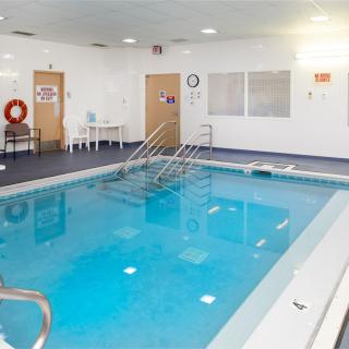 An indoor swimming pool area with safety equipment and seating.