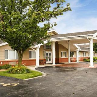 A single-story building with a covered entrance and adjacent parking lot.