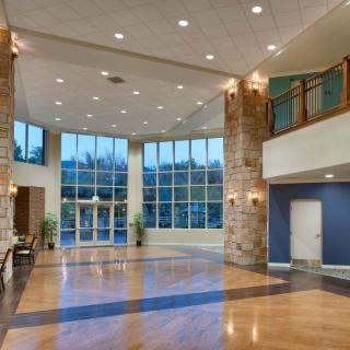 A modern and spacious lobby with large windows and elegant lighting.