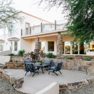 A modern house with a landscaped patio featuring outdoor seating and a garden area.