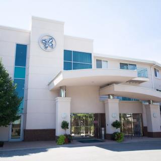 A modern building with large windows and a prominent entrance on a sunny day.