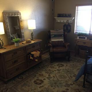 A cozy and stylish room featuring wooden furniture, soft lighting, and a decorative rug.