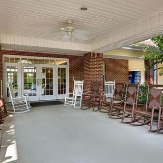 A welcoming porch with multiple rocking chairs facing the entrance.