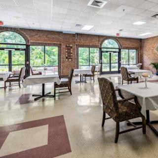 A spacious and inviting dining area featuring tables and chairs with ample natural light coming through large windows.