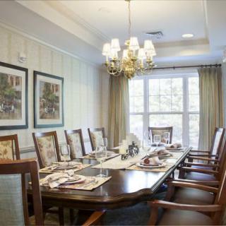 A well-appointed dining room featuring a large table, elegant chairs, and a chandelier.