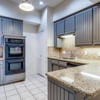 Modern kitchen with granite countertops and double oven.