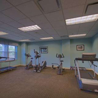 A small gym with exercise equipment including treadmills and stationary bikes.