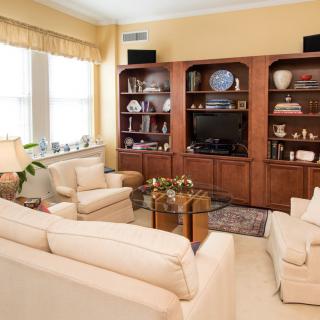 A cozy living room with comfortable seating, a wooden entertainment center, and tasteful decor.