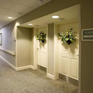 A hallway with two decorated doors adorned with plant arrangements.
