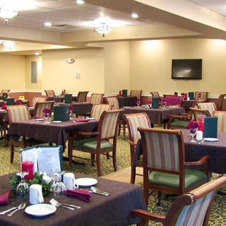 A well-arranged dining room with tables and chairs set for service.