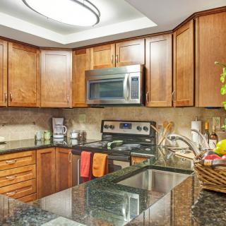 A modern kitchen with wooden cabinets and stainless steel appliances.