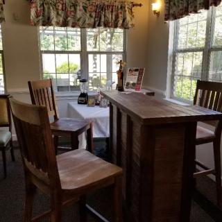 A cozy dining room with wooden furniture and large windows.