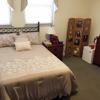 A neatly arranged bedroom featuring a comfortable bed and decorative elements.