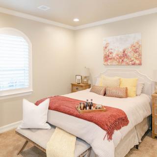 A cozy and well-decorated bedroom with warm tones and comfortable bedding.