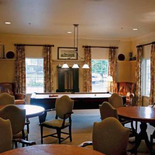 A cozy room with tables, chairs, and ambient lighting.