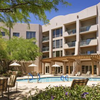 A sunny day at a hotel with an inviting outdoor pool area.