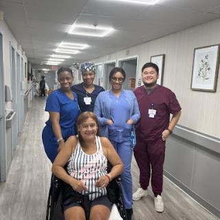 Healthcare team assisting a patient in a hospital corridor.