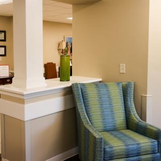 A cozy waiting area with a striped chair and welcoming decor.