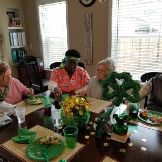 A group of people celebrating St. Patrick's Day with green-themed decorations and food.