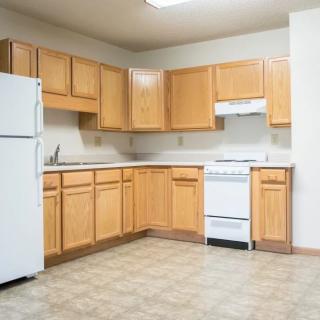 Simple kitchen with wooden cabinets and basic appliances.