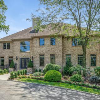 A large brick house with well-maintained landscaping and a wide driveway.