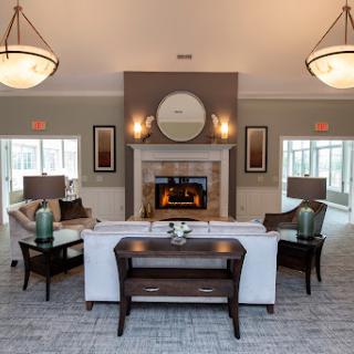 A modern and inviting living room featuring a fireplace, stylish furniture, and warm lighting.