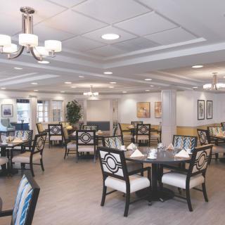 A modern and elegantly designed restaurant dining area with neatly arranged tables and chairs under soft lighting.