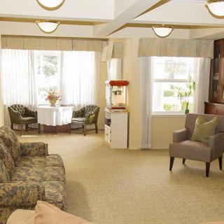 A cozy living room with comfortable seating, natural lighting, and a popcorn machine by the window.