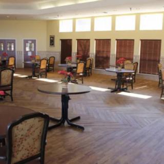 A well-lit dining area with several tables and chairs arranged around the room.