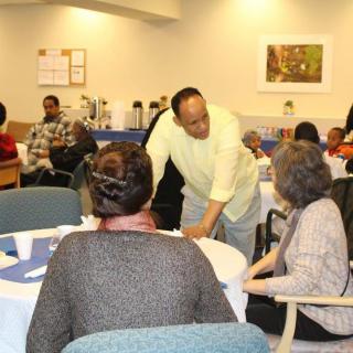 A group of people engaging in conversation at an indoor gathering.