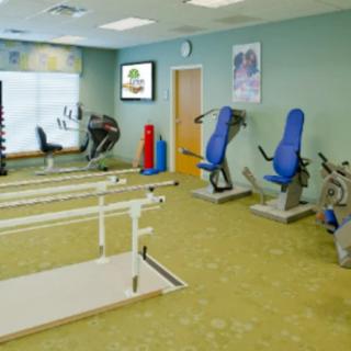 A rehabilitation gym equipped with exercise machines and parallel bars.