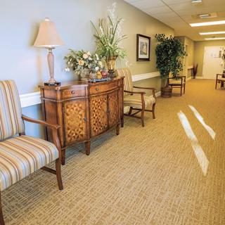 A well-decorated hallway featuring elegant furniture, plants, and soft lighting.