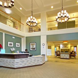 A spacious and elegantly designed lobby with chandeliers and a reception desk.