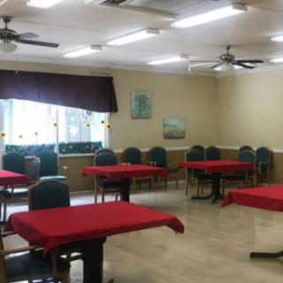 An empty classroom with tables and chairs arranged neatly.