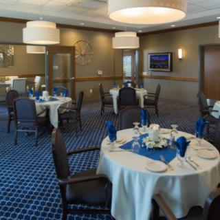 A formal dining area with elegantly set tables and blue accents, ideal for events or banquets.