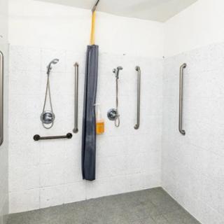 An accessible shower with multiple grab bars for safety.
