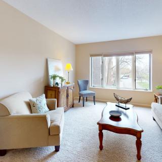 A cozy living room with comfortable sofas, a wooden coffee table, and large windows allowing natural light.
