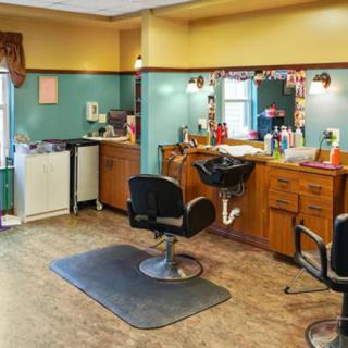 An empty barber shop interior with styling chairs and mirrors.
