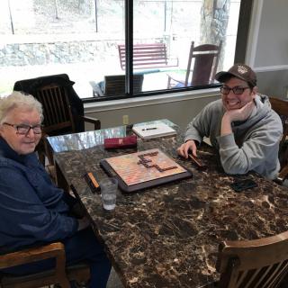 Two people sitting at a table working on a puzzle.