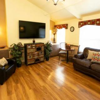 A cozy living room with comfortable seating and a flat-screen TV on the wall.