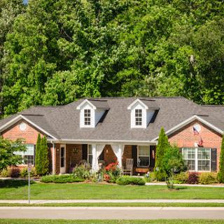 A charming brick house surrounded by lush greenery.