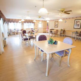 A welcoming community dining room with tables and chairs set up for gathering.