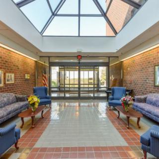 A spacious lobby with comfortable seating and a glass ceiling allowing natural light to brighten the space.