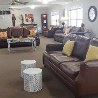 A cozy living room featuring brown leather sofas and decorative pillows, with a modern coffee table in a well-lit space.
